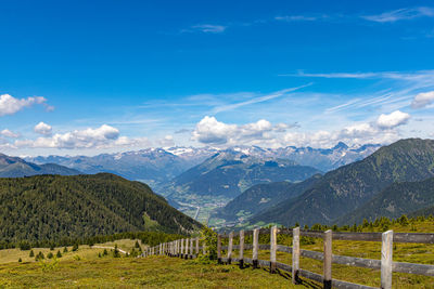Scenic view of landscape and mountains against blue sky