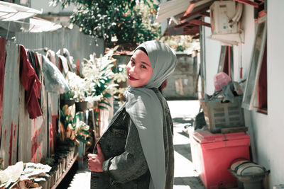 Portrait of young woman looking at store