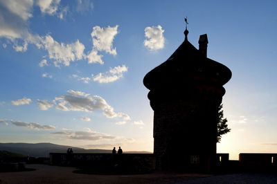 Silhouette of building against cloudy sky