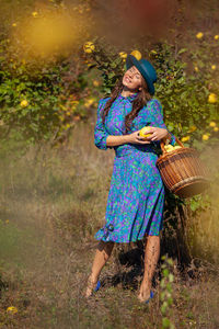 Smiling woman with fruits standing on land
