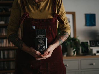 Midsection of man photographing at home