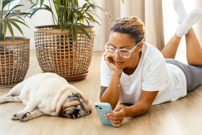 Side view of young woman with dog at home