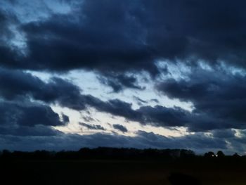 Silhouette of landscape against cloudy sky