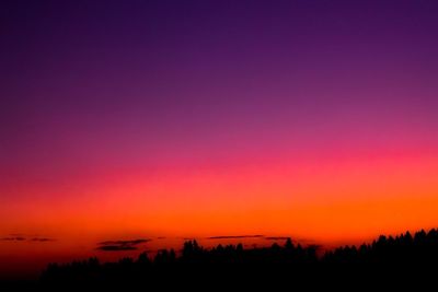 Scenic view of silhouette landscape against orange sky