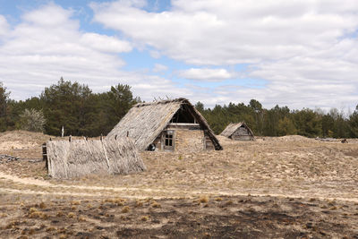 Abandoned house on field against sky