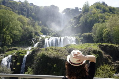 Rear view of woman looking at waterfall