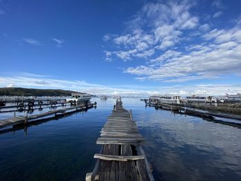 Pier over sea against blue sky