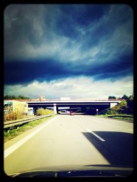 Road passing through dramatic sky