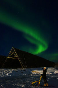 Man standing on snow covered mountain at night