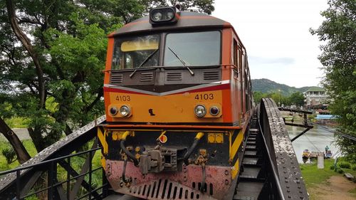 Train on railroad track in city against sky