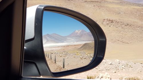 Reflection of mountains on side-view mirror