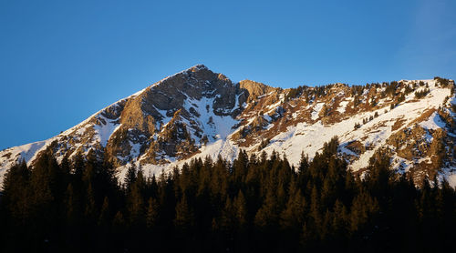 Scenic view of snowcapped mountains against clear blue sky