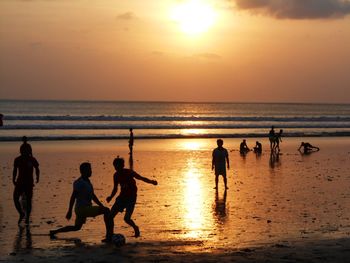 Silhouette people at beach during sunset