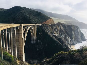 Arch bridge over river against sky