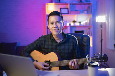 Portrait of man using laptop at home