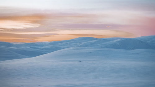 Scenic view of snowcapped mountains against sky during sunset