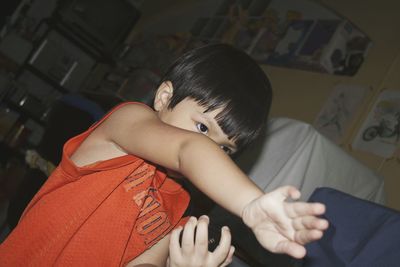 Close-up of cute boy gesturing at home