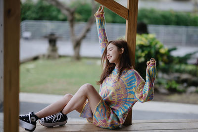 Portrait of young woman sitting on swing