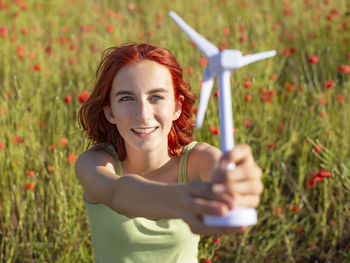 Portrait of young woman standing against plants