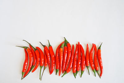 Close-up of red chili peppers against white background