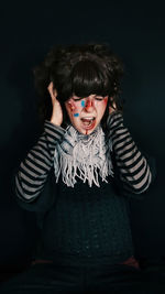 Close-up of woman shouting against black background