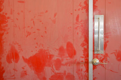 Orange metal door with lock and ladder, part of electric service truck, old, rusty and dusty