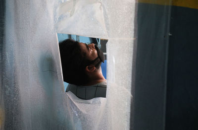 Portrait of woman looking through window