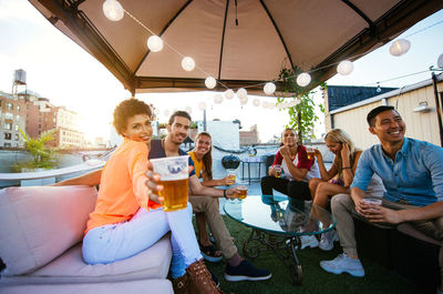 Friends enjoying drinks while sitting in restaurant