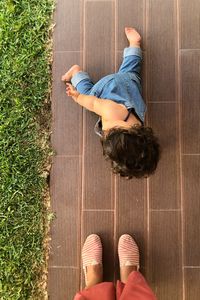 Low section of woman standing with baby crawling on floor