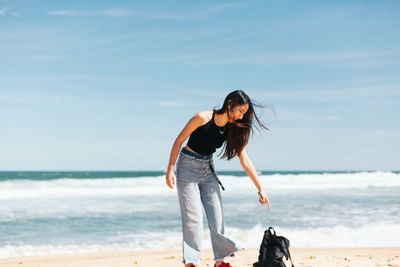 Full length of man standing at beach against sky