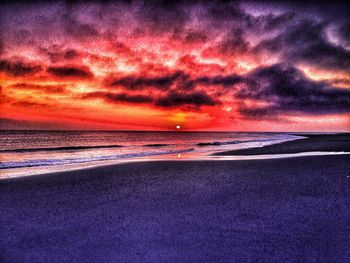 Scenic view of sea against dramatic sky during sunset