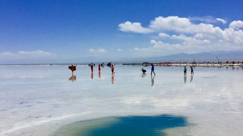 People on beach against sky