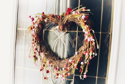 Close-up of red flowers hanging on window at home