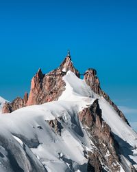 Scenic view of snowcapped mountains against clear blue sky