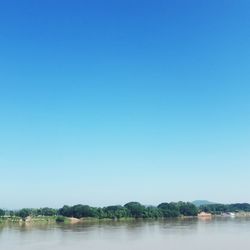Scenic view of lake against clear blue sky
