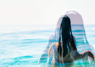 Rear view of woman looking at sea against sky