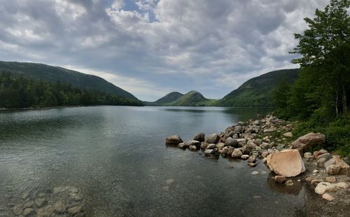 Rocks by lake against sky