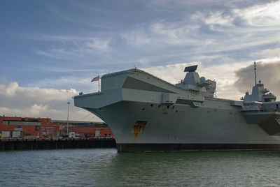 Ship moored at harbor against sky