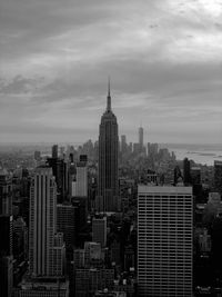 Modern buildings in city against cloudy sky