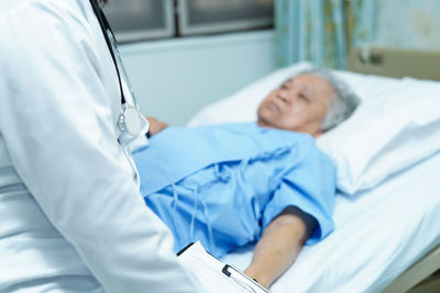 Midsection of person lying on bed