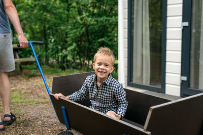 Portrait of cute boy sitting in cart