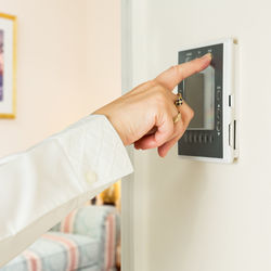 Cropped hand using intercom at home