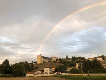 Rainbow over building against sky