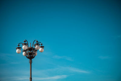 Low angle view of street light against blue sky