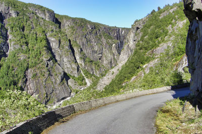 Road amidst rocks and trees against sky