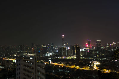 Illuminated buildings against sky at night