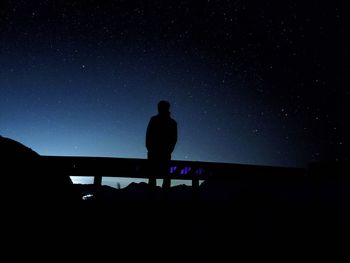 Silhouette man standing against sky at night