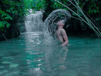 Full length of shirtless boy in water