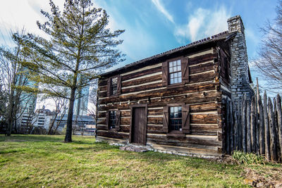 Old abandoned house on field against sky