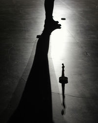 Low section of silhouette people standing on tiled floor